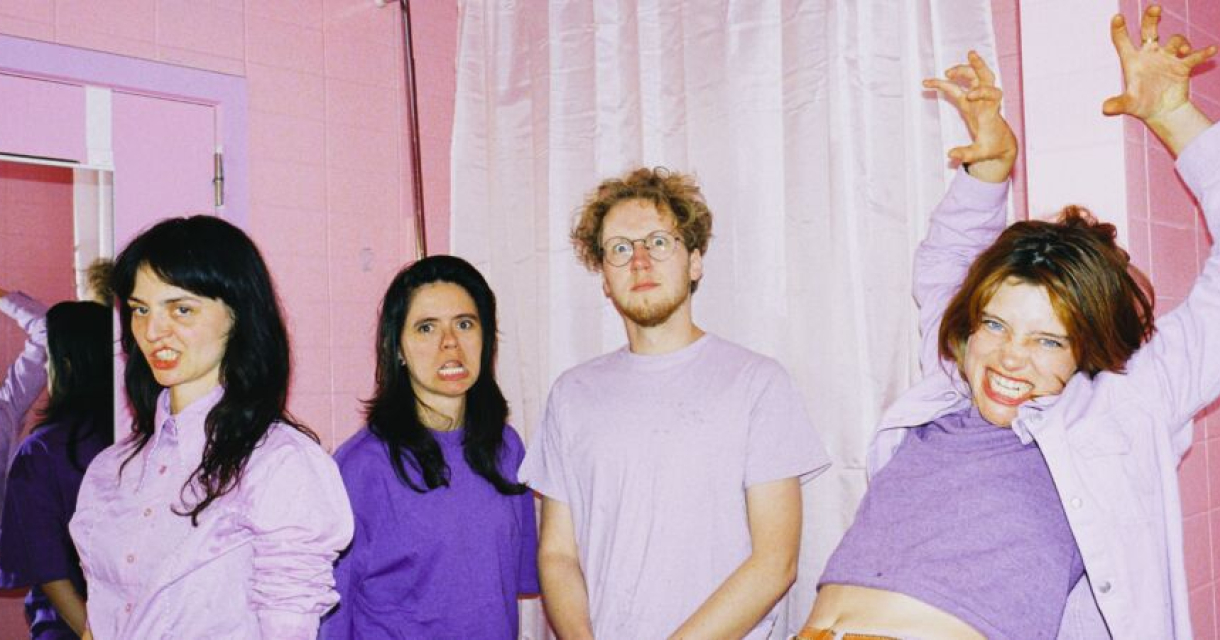 Band Maria Iskariot rebels in paars op mierzoet roze achtergrond met kanten vitrage wat past bij de cult liefelijk monster uitstraling.