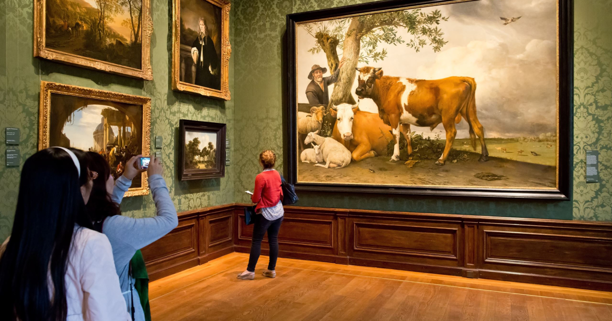 Zaal in het Mauritshuis waar mensen kijken naar en foto's maken van het schilderij De stier van Paulus Potter