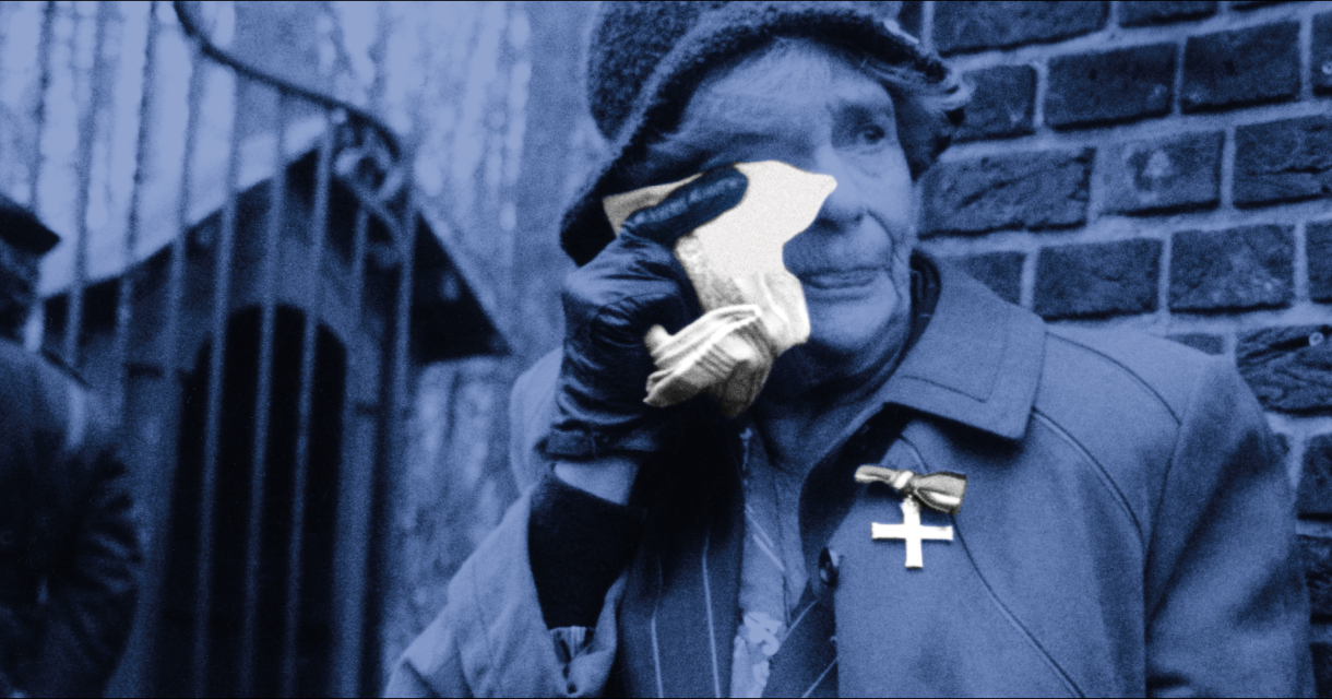 Foto: Bert Verhoeff. Een oudere vrouw veegt een traan weg tegen een stenen muur.