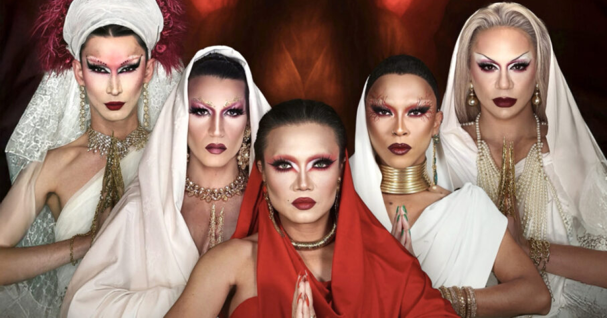 Vijf drag performers met opvallende make-up en kleding staan voor een donker achtergrond