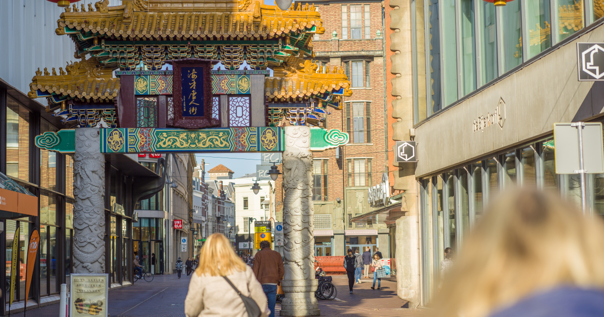 Fietser voor een Chinese poort in de Wagenstraat. 