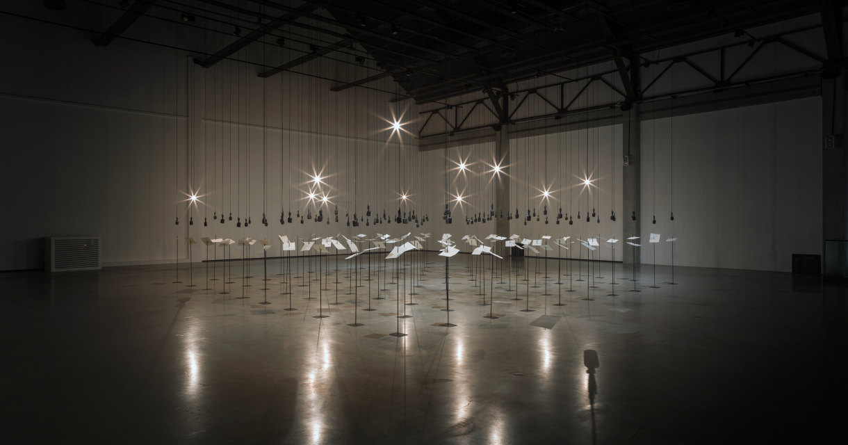 An art installation with illuminated objects in an empty space.