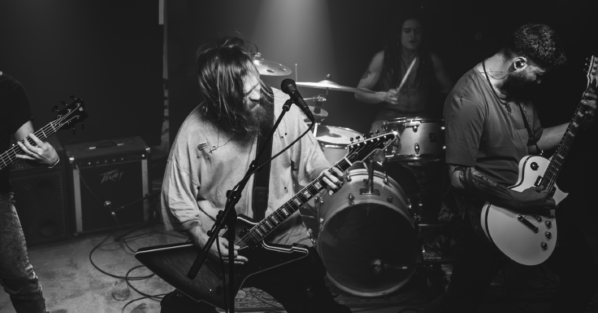 Vier muzikanten spelen samen in een donkere zaal.