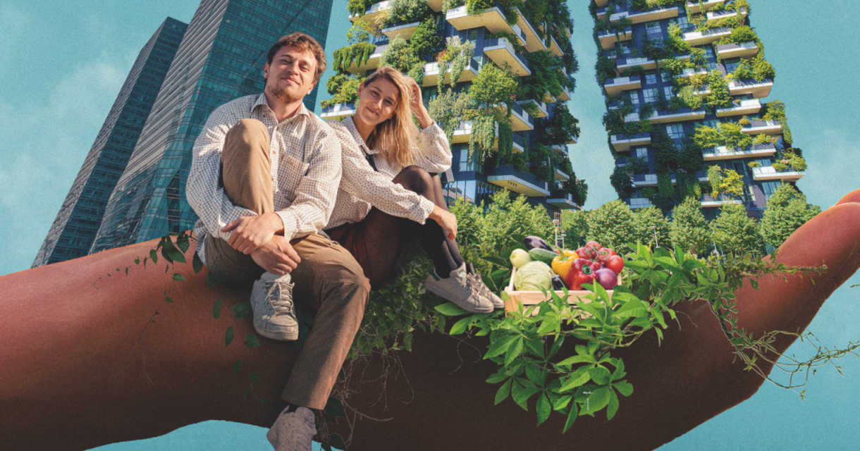 A young couple sitting on a hand with green buildings in the background.