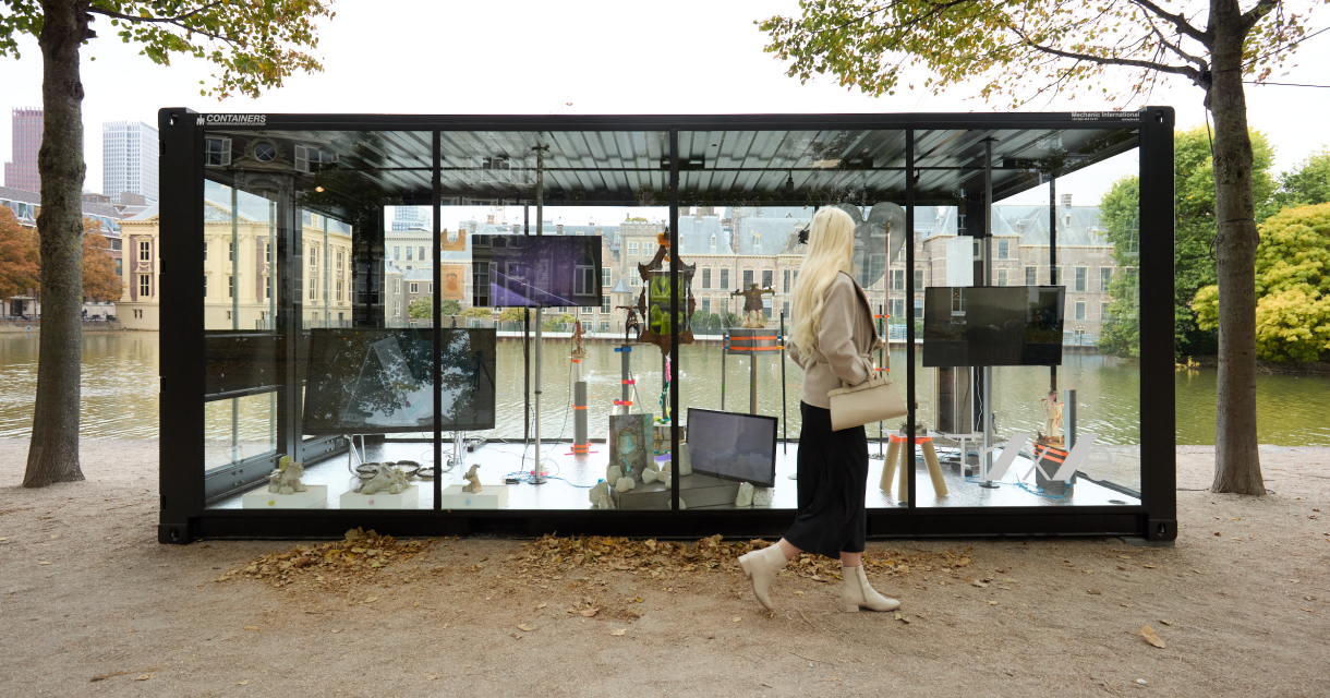 Een vrouw loopt langs een moderne kunstinstallatie bij de Hofvijver.