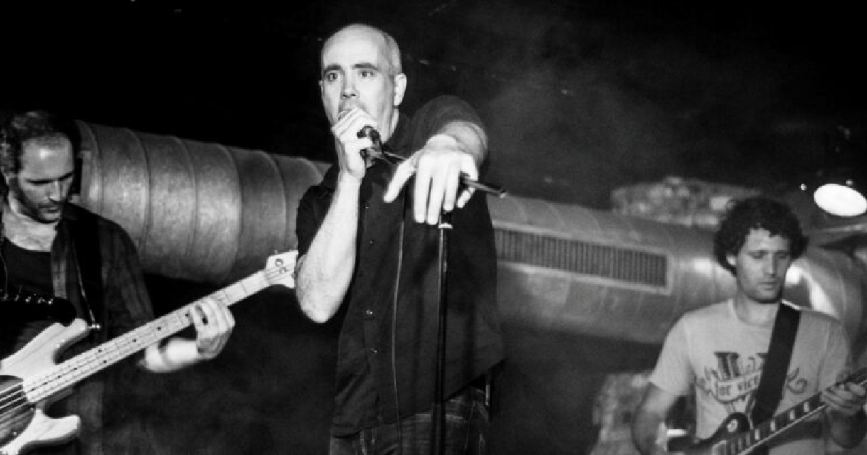 Muzikanten op het podium. Drie muzikanten spelen in een donkere omgeving.