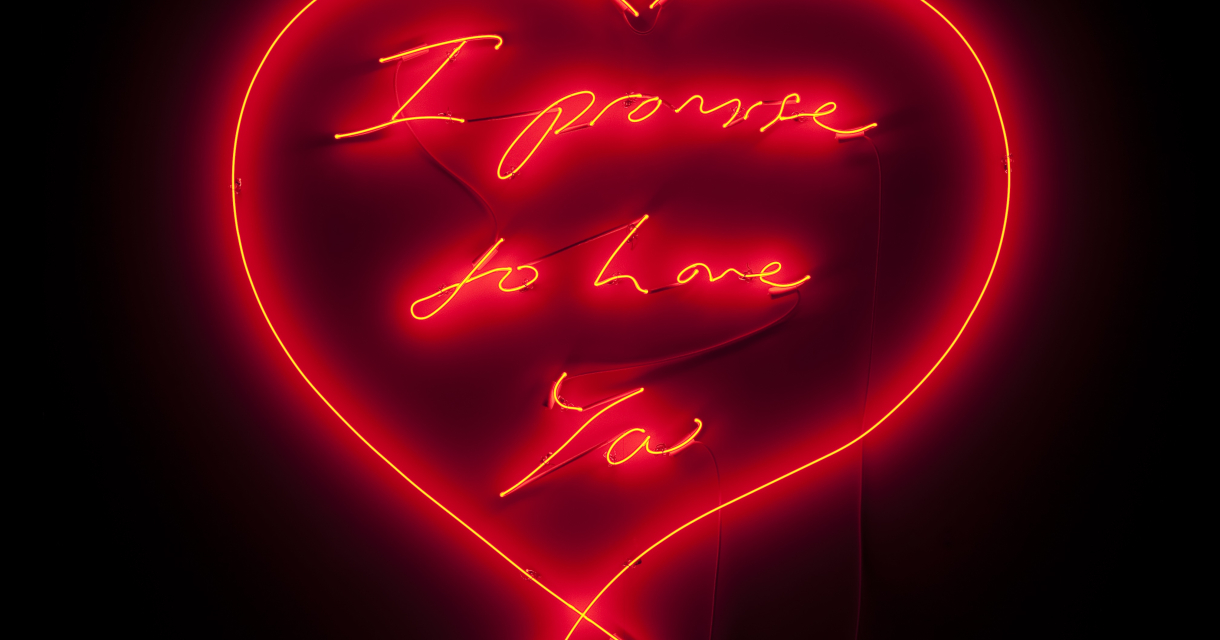 Red neon light in heart shape with the text 'I promise to love you'.