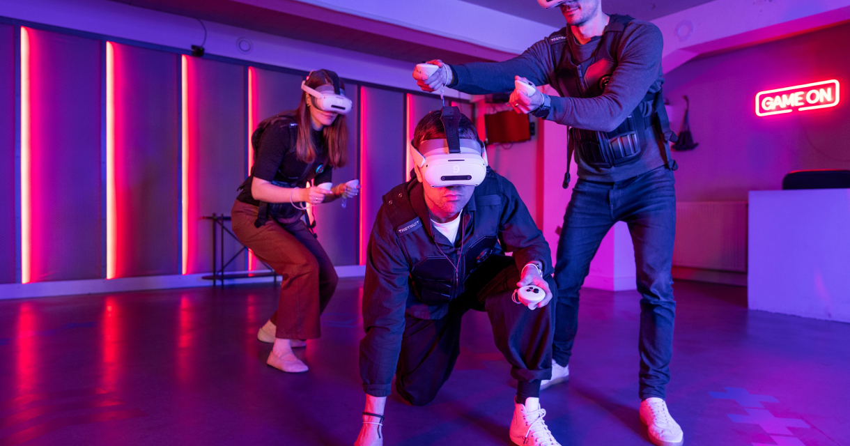 Amaze VR. Drei Personen interagieren mit virtueller Realität in einem bunten Raum.