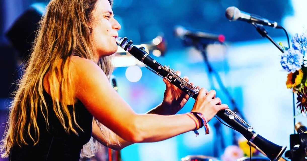ALBA Theaterhuis Voorleesconcert. Een vrouw met lang haar speelt een klarinet tijdens een optreden.