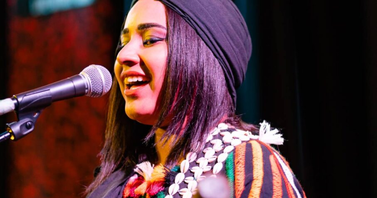 Een jonge artiest tijdens het Gnawa Festival, spelend op een traditioneel snaarinstrument en volledig opgaand in de ritmische muziek. Een jonge artiest tijdens het Gnawa Festival, spelend op een traditioneel snaarinstrument en volledig opgaand in de ritmische muziek.
