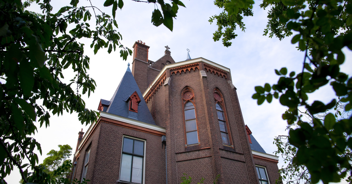 Bovenkant van de Barthkapel door groene takken heen gefotografeerd.