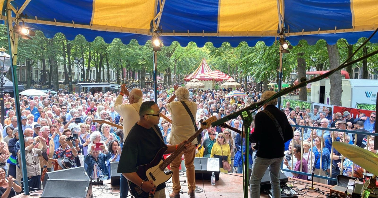 Een band speelt voor een grote menigte in Den Haag.