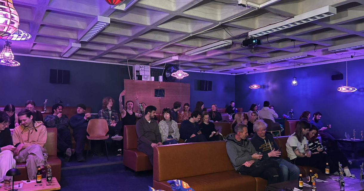 Mensen zitten in een filmzaal met sfeervolle verlichting.