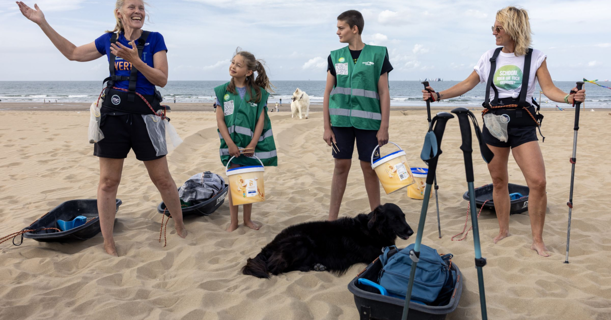 Groepje mensen op het strand met knijptangen maken zich klaar om het strand op te ruimen. 