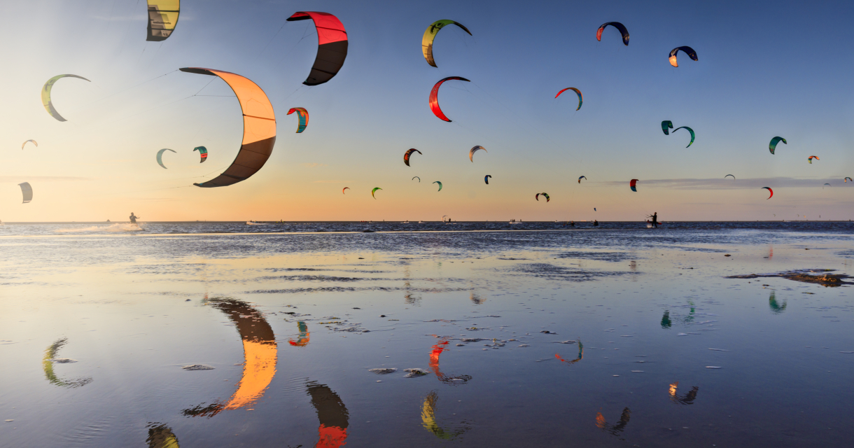 Een lucht vol kites van kitesurfers op het strand van de Zandmotor bij Kijkduin