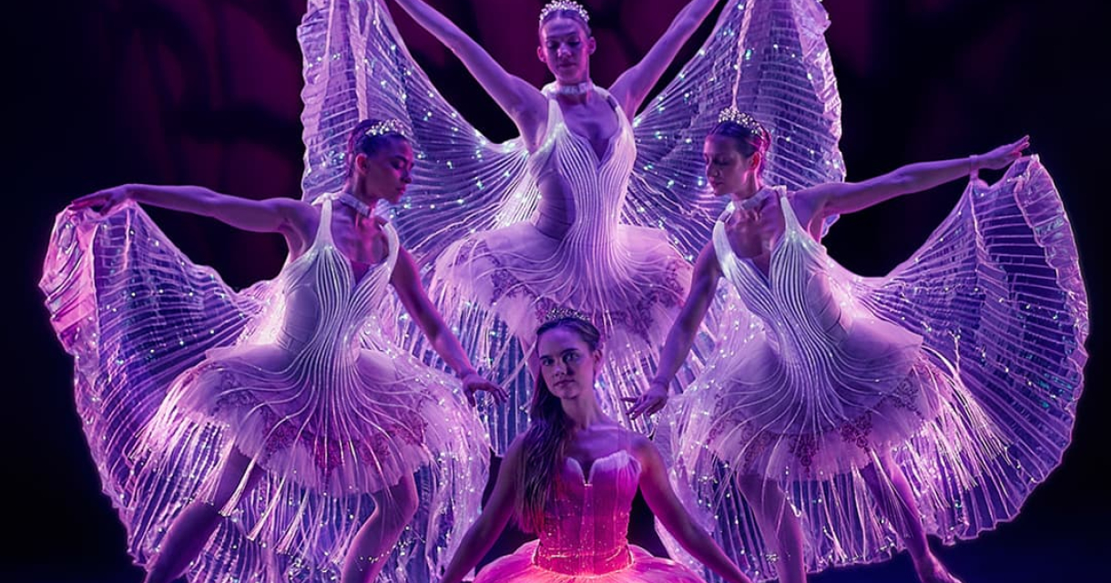 Vier balletdansers in transparante, lichtgevende jurken