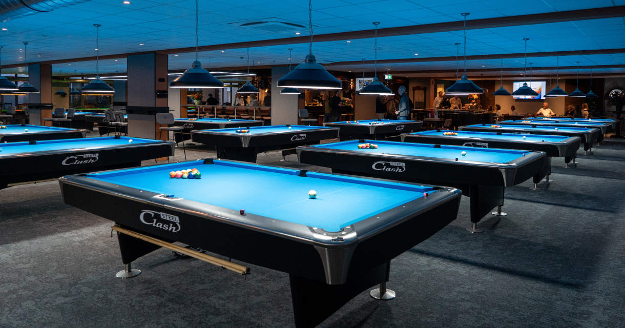 A spacious billiard room featuring several blue billiard tables.