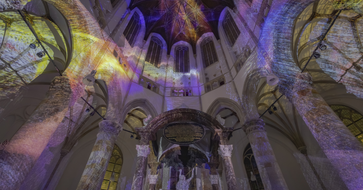 Kunstinstallatie in historische setting. Binnenkant van een kerk met kleurrijke lichtprojecties