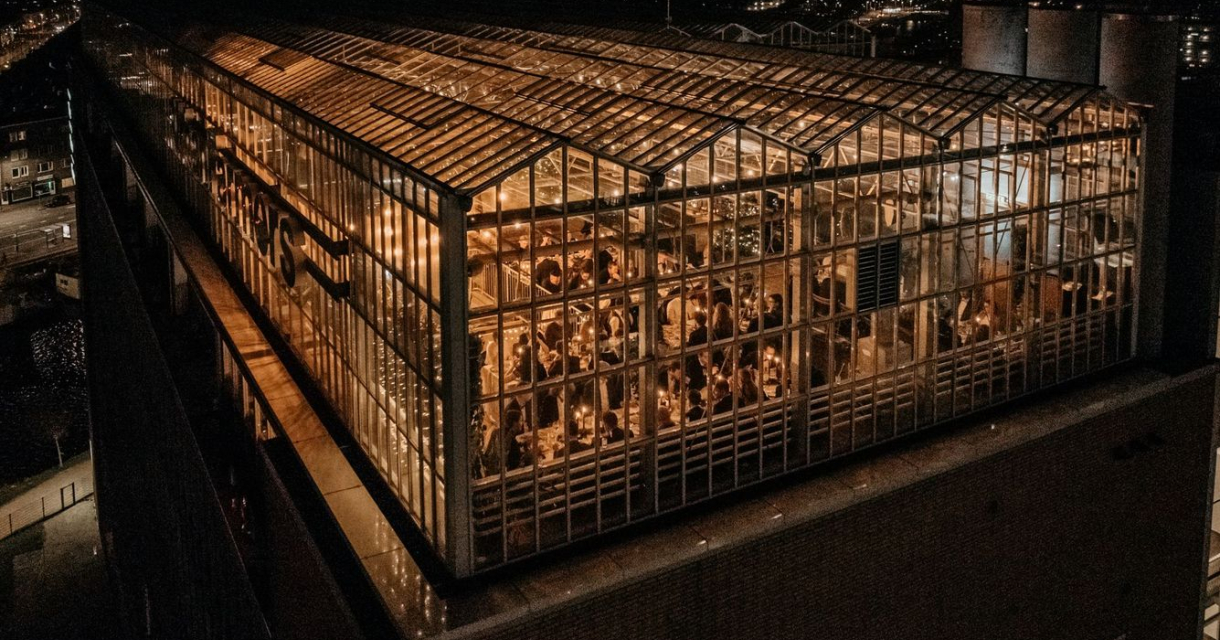 Overzicht van een verlicht rooftop restaurant bij nacht (c) Haags Hoog