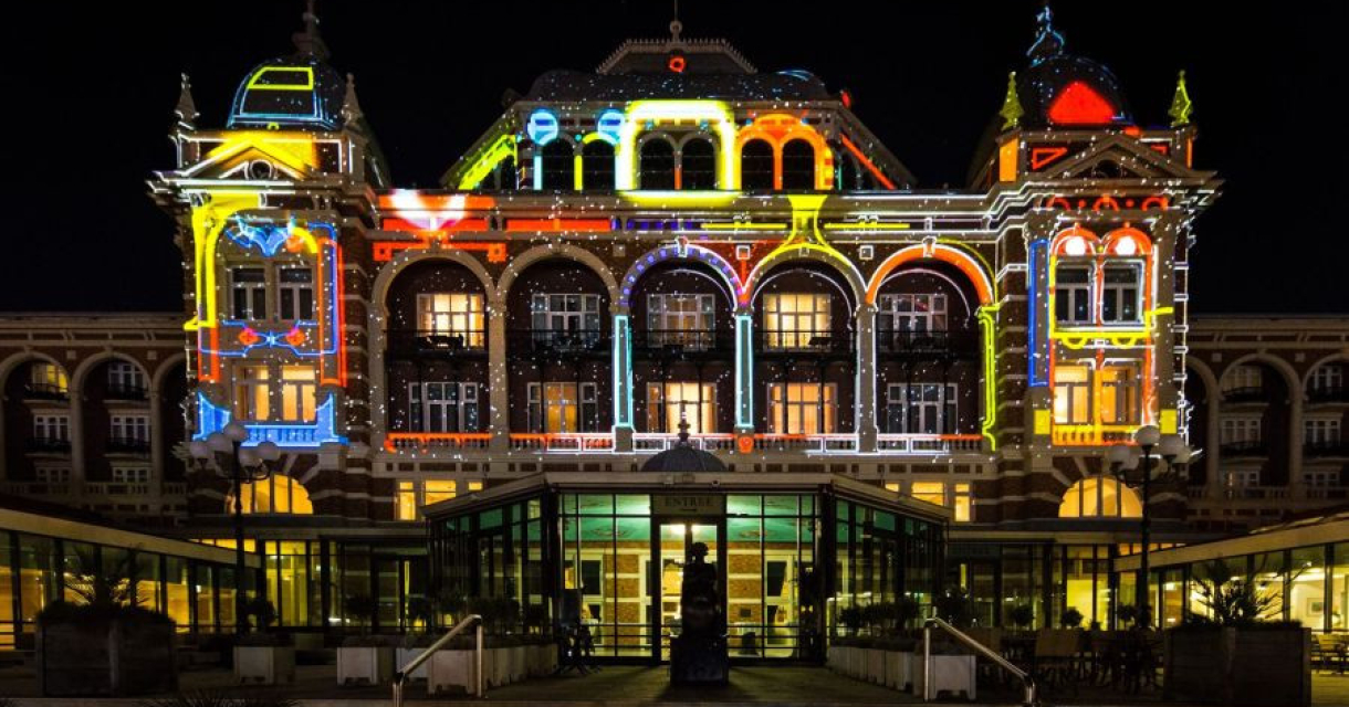 Het Kurhaus in Scheveningen, verlicht met kleurrijke projecties.