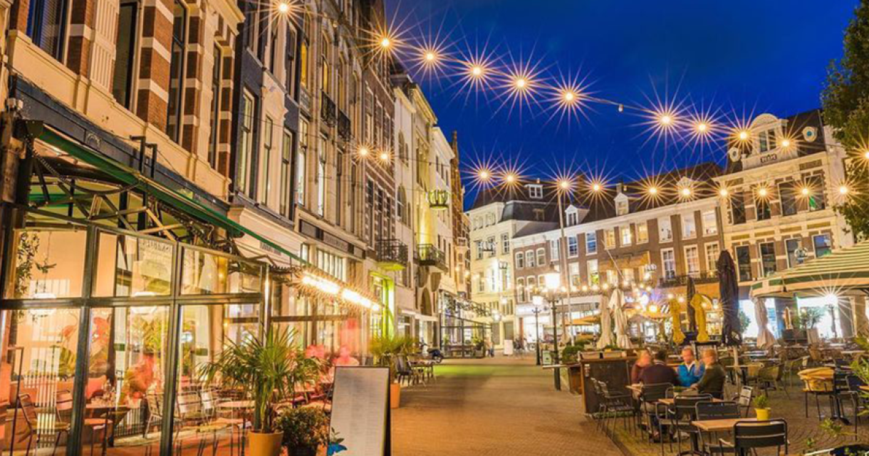 Terrassen op de Plaats Den Haag in de avond sfeervol verlicht.