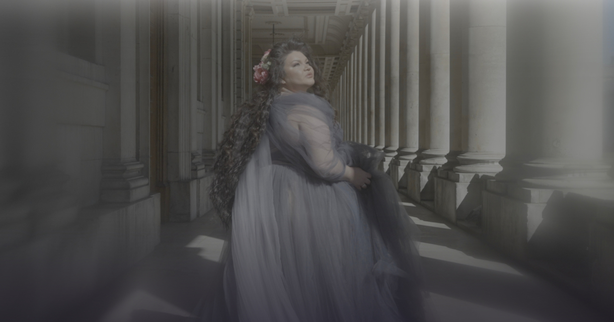 mezzo-soprano Kseniia Nikolaieva in een zuilen gang in een lange jurk