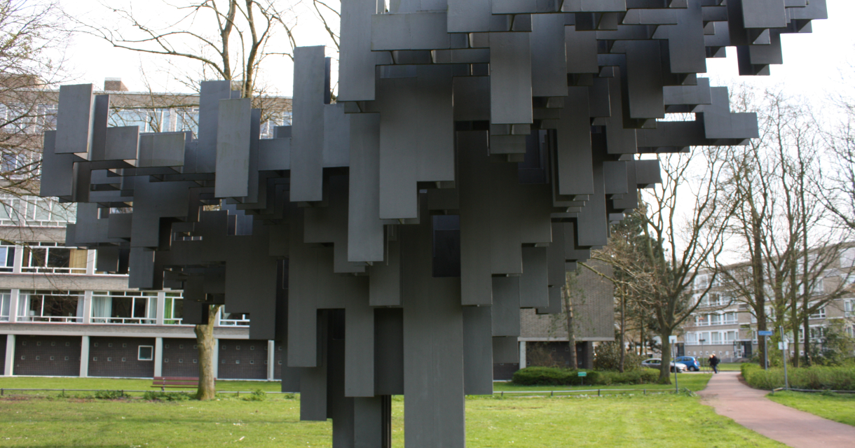 Abstracte sculptuur van zwarte blokken in een park.