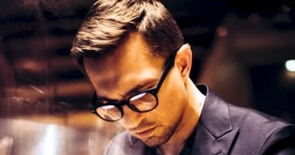 Een jongeman met bril speelt piano