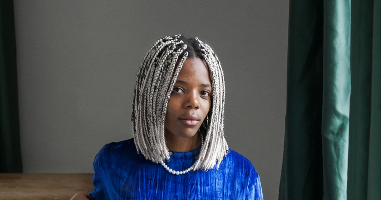 Vrouw met een kort kapsel van gevlochten haar en een blauwe blouse