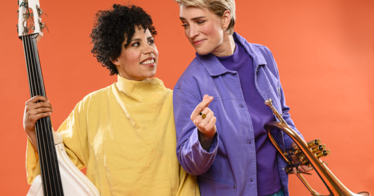 Twee vrouwen poseren met een contrabas en een trompet.