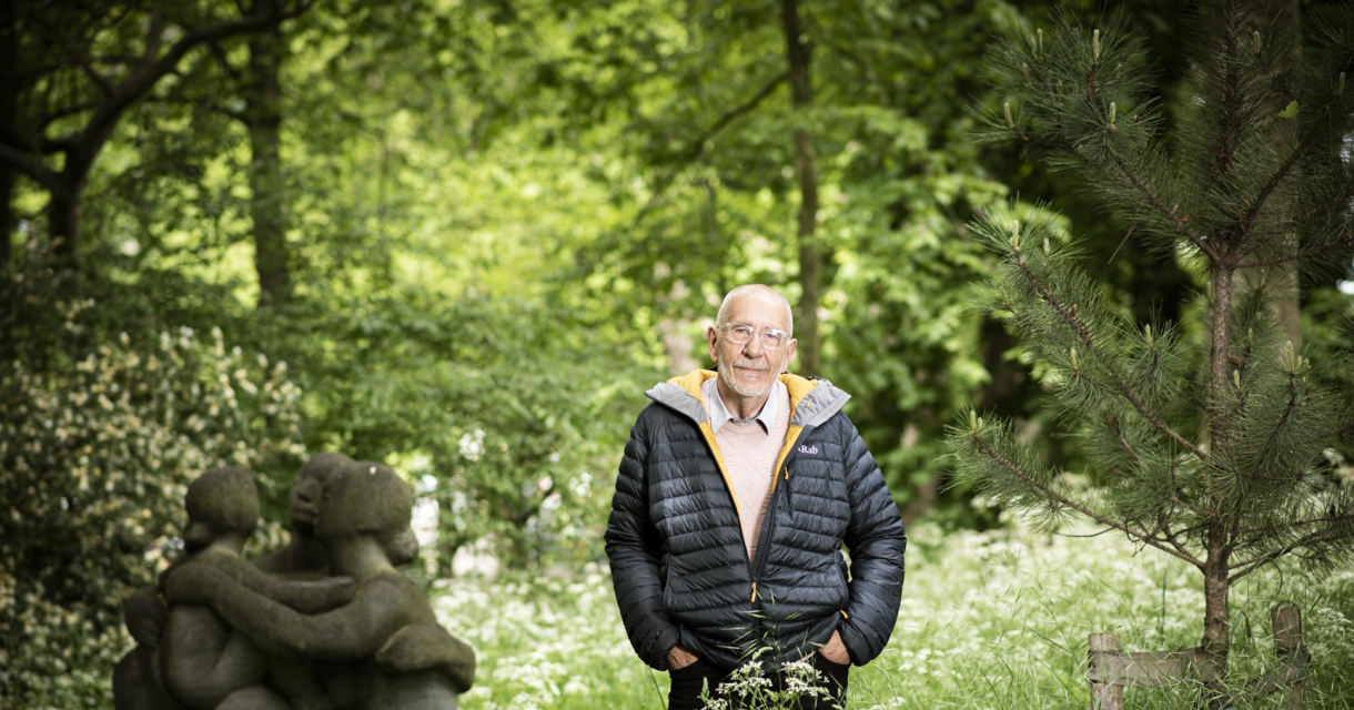 Matthijs Schouten - Copyright Diane van der Marel Een oudere man staat in een groene tuin met sculpturen.