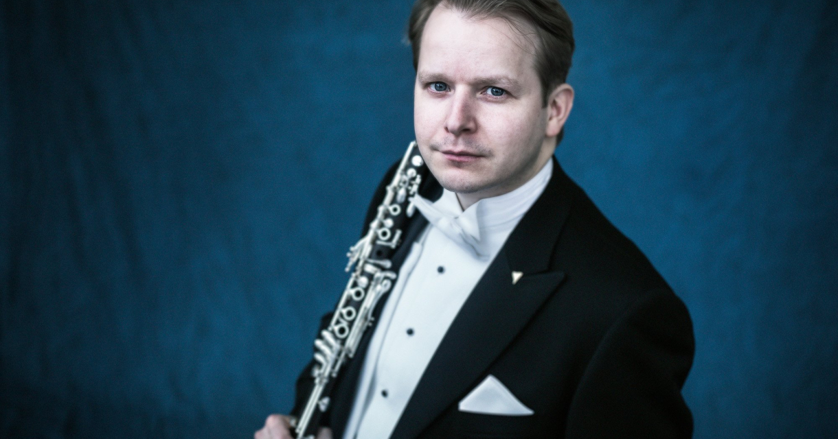 Man in smoking met klarinet, blauwe achtergrond