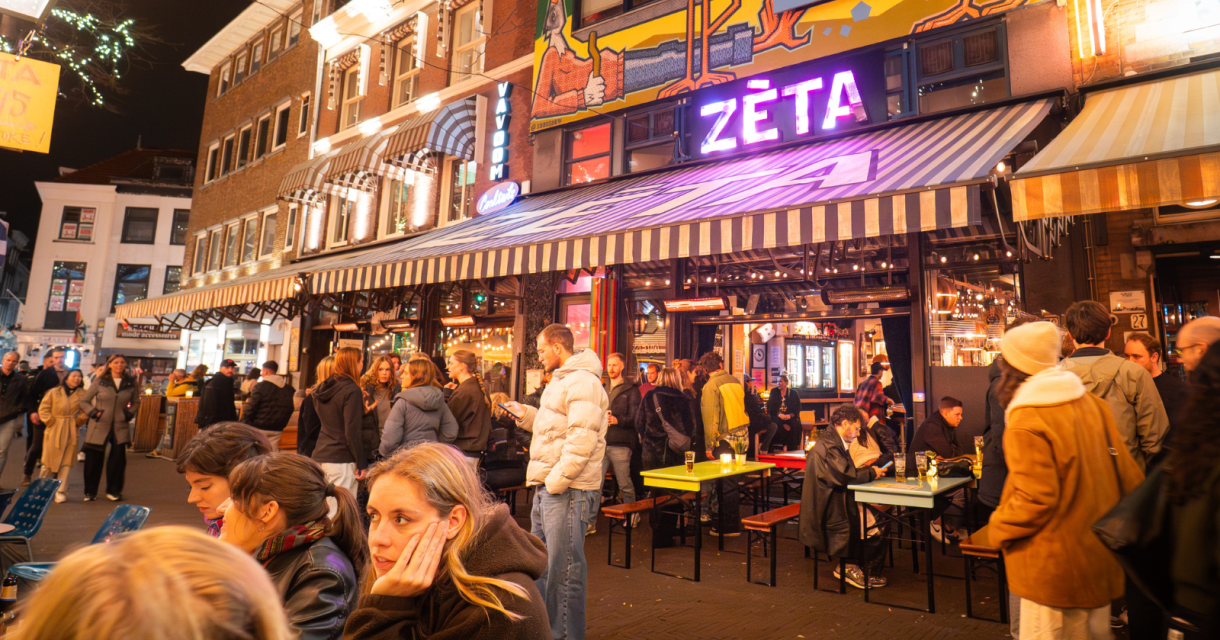 Een levendige straat met mensen en een bar met Neon ZETA