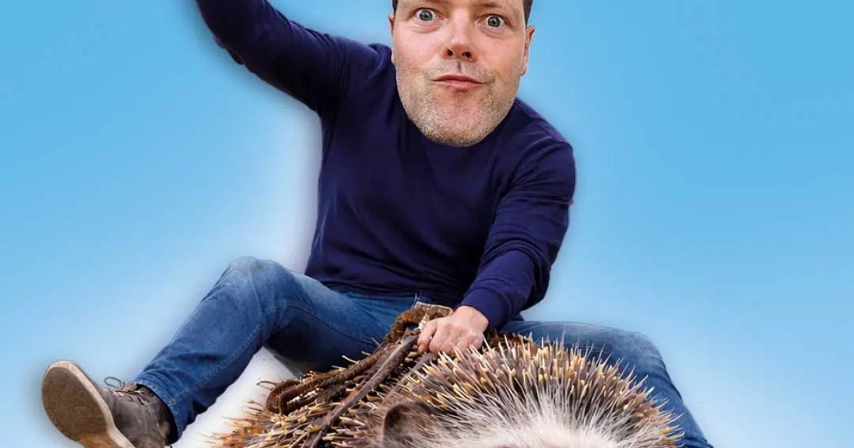 Een man met een grote kop zit op een egel met een glimlach.