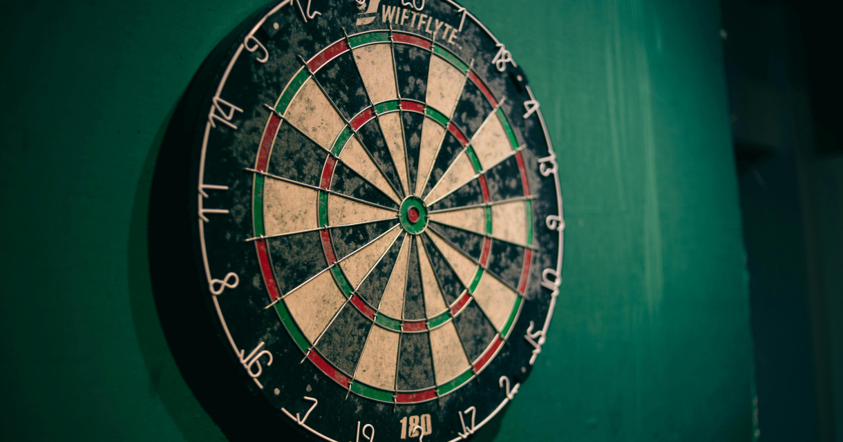 Een dartbord aan een groene muur