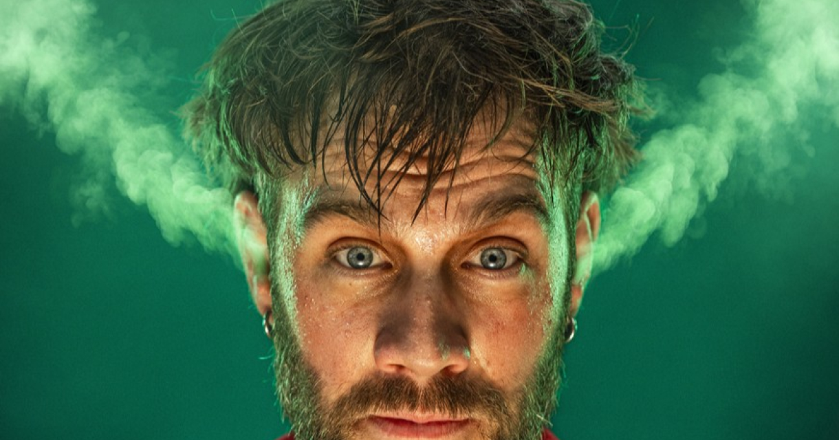 Een man met een verbaasde blik en rook die uit zijn haar komt.