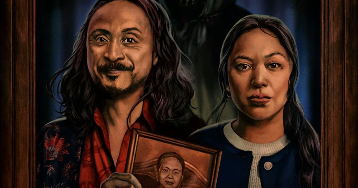 Twee mensen poseren met een foto, een sinistere figuur op de achtergrond.