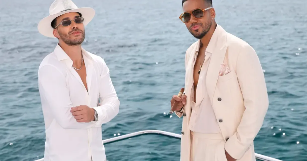 Two men in stylish outfits on a boat with the sea in the background (c) Pablo Garcia