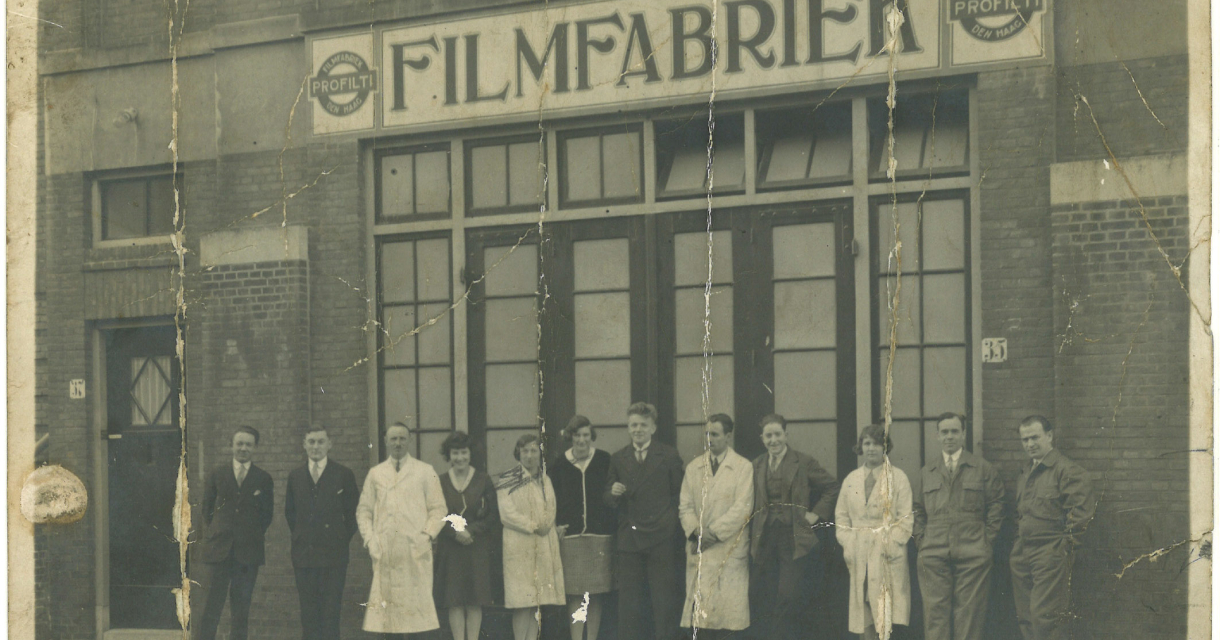 Een groep mensen poseert voor een gebouw met 'Filmfabriek' op de gevel.