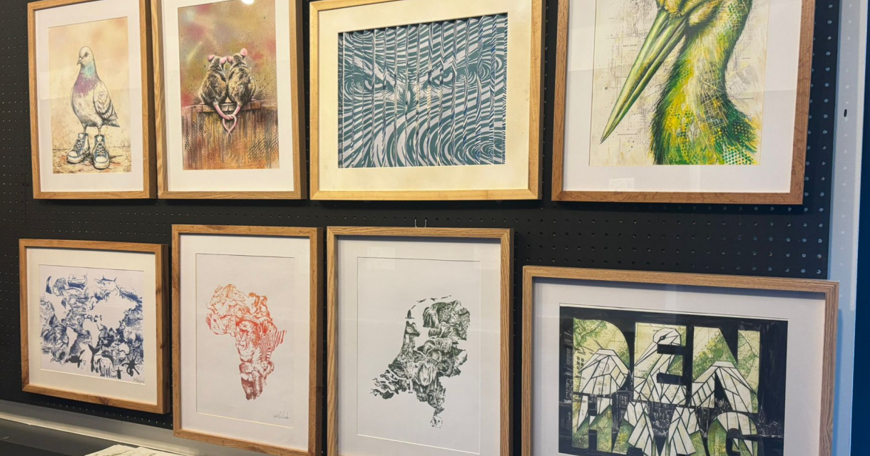 Verschillende kunstwerken aan een muur in Den Haag.