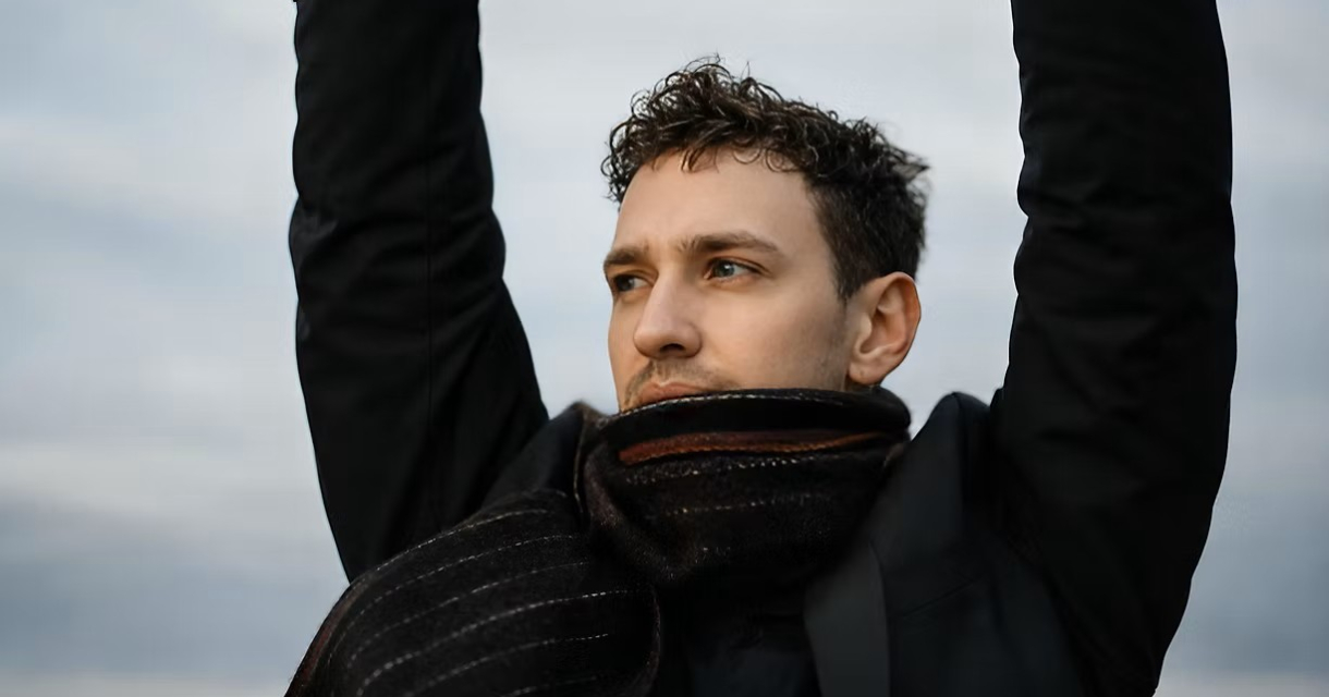 Een man met een sjaal houdt zijn arm omhoog