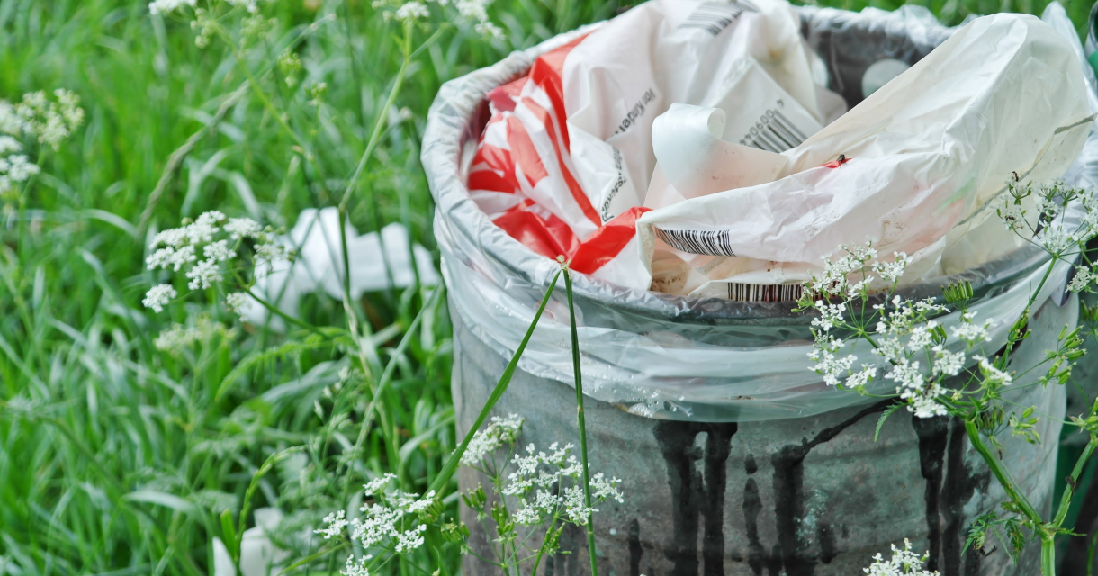 Volle prullenbak in het gras