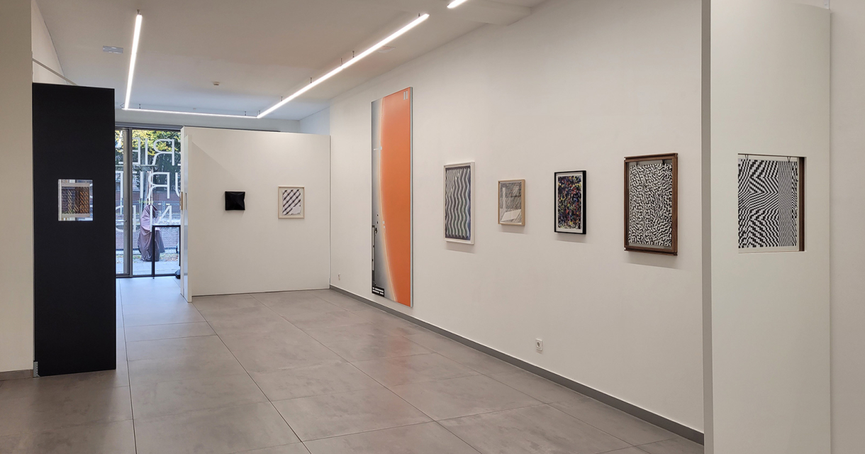 Moderne galerie met strakke witte muren, geometrische kunst aan de wand en daglicht van achterin de ruimte Moderne galerie met strakke witte muren, geometrische kunst aan de wand en daglicht van achterin de ruimte