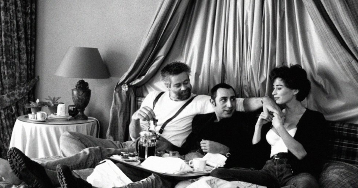 Zwart wit foto van drie mensen zittend in een hemelbed