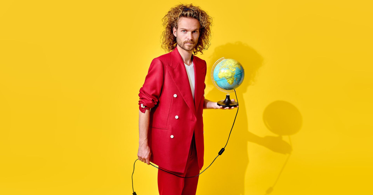 Man in een rood pak houdt een wereldbol vast met een kabel