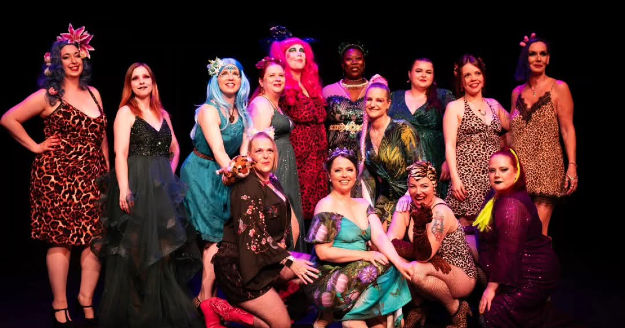 Groep artiesten poseert op een podium