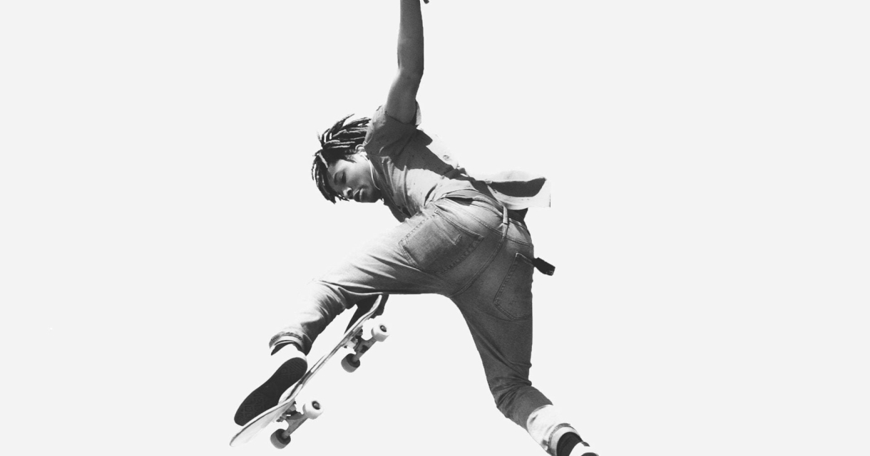 Een skater maakt een sprongetje met een skateboard.