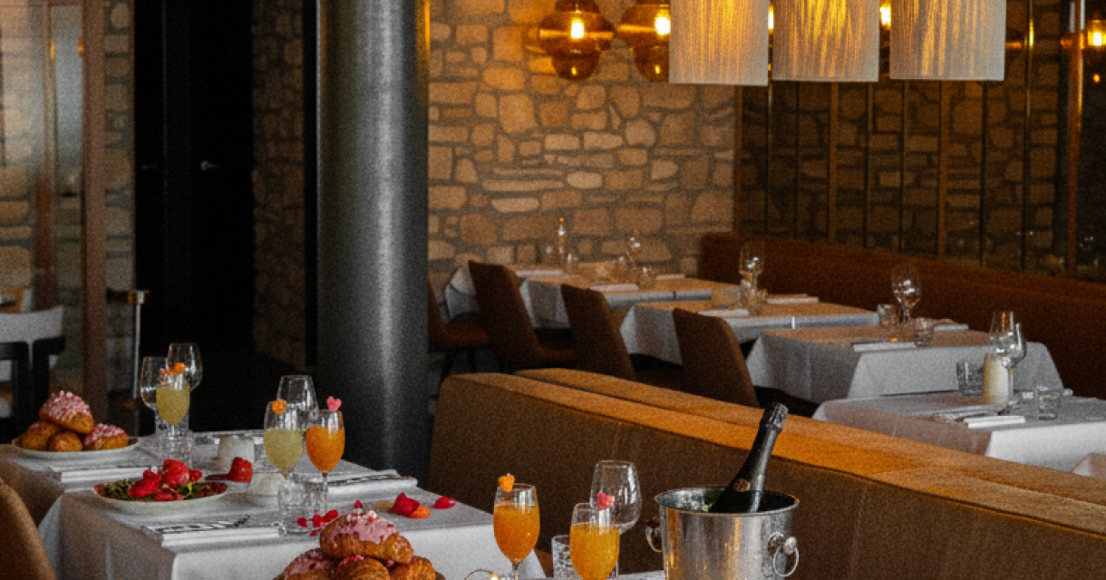 Gedekte tafels in restaurant Lemongrass voor Valentijns brunch. Op de met wit linnen gedekte tafels rozenblaadjes, glazen sap en croissants.