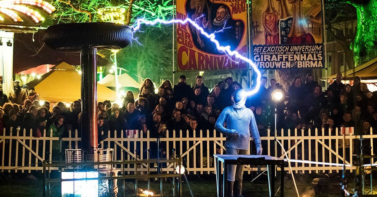 Man die onder stroom lijkt te staan met toeschouwers bij een winters buitenfestival.
