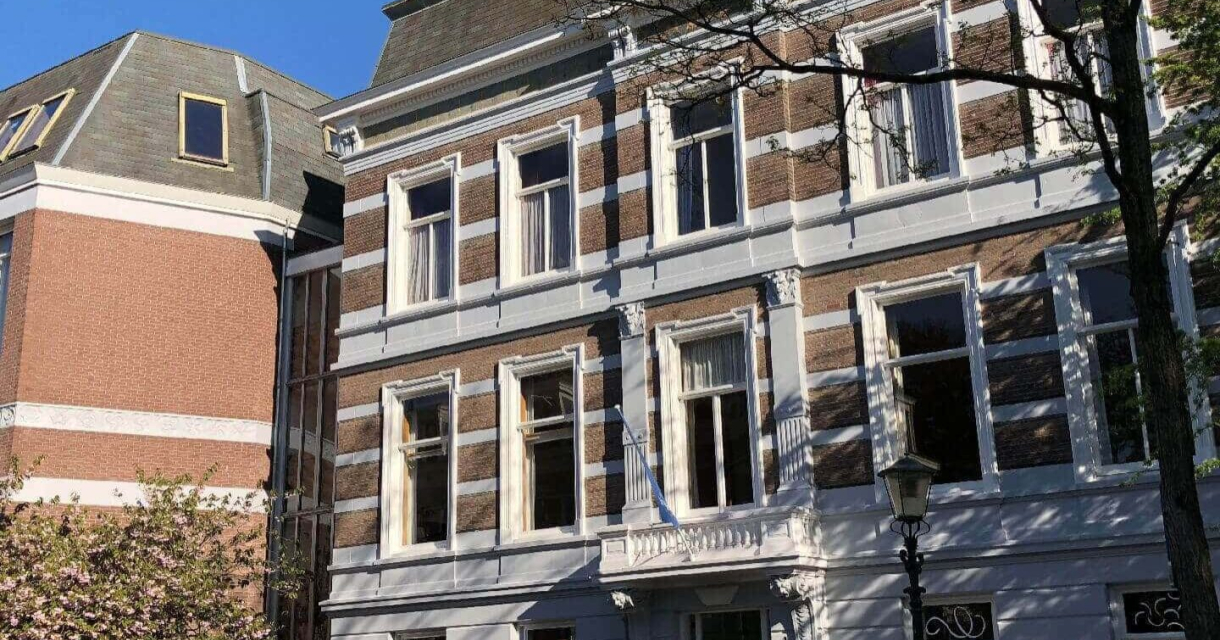 Een historisch gebouw met een gevel van baksteen en witte accenten.